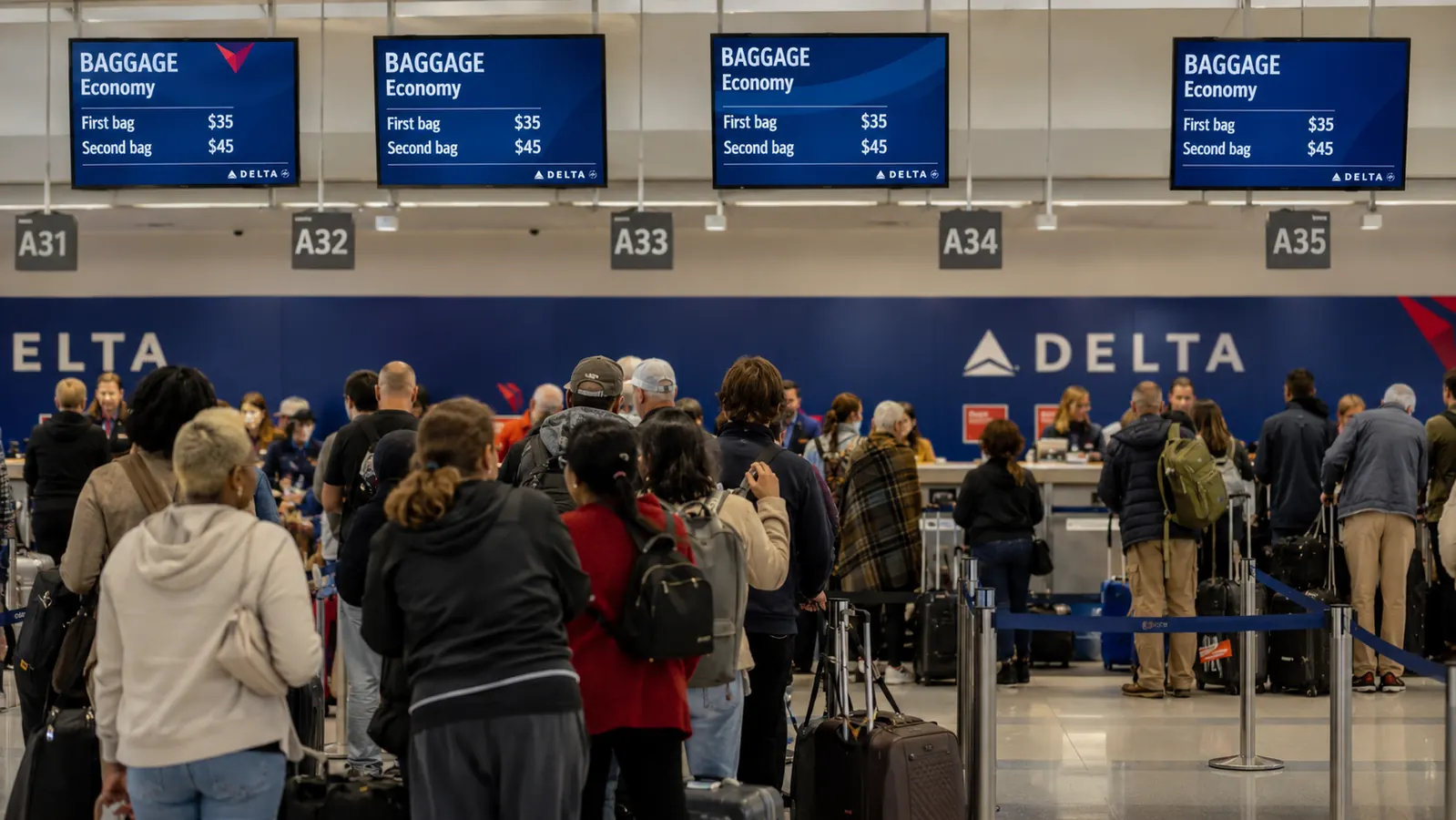 Airport check-in counter with overhead baggage fee signage visible
