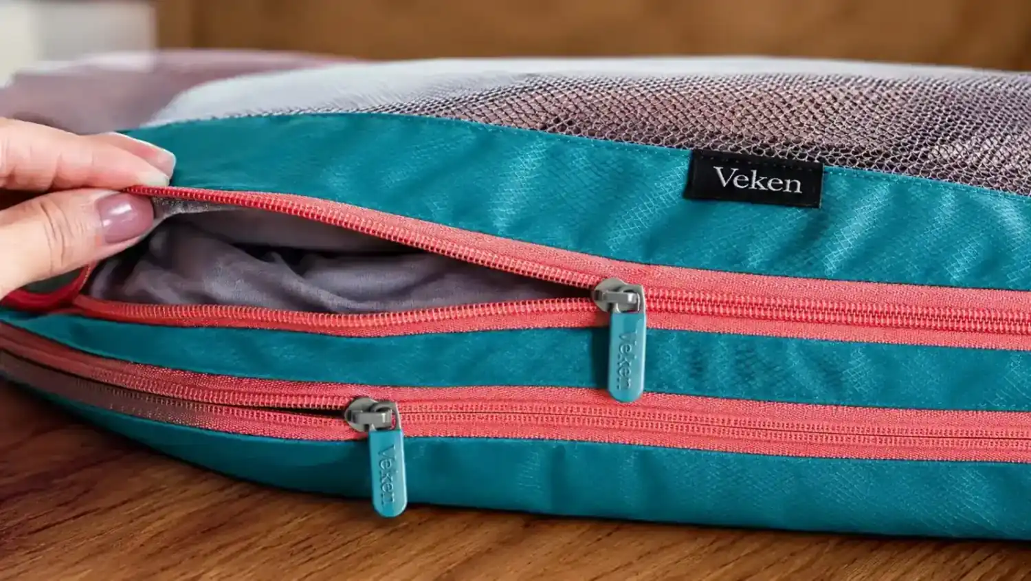 Close-up of the double zipper system on a Veken compression packing cube, showing both zipper tracks before and after the compression step