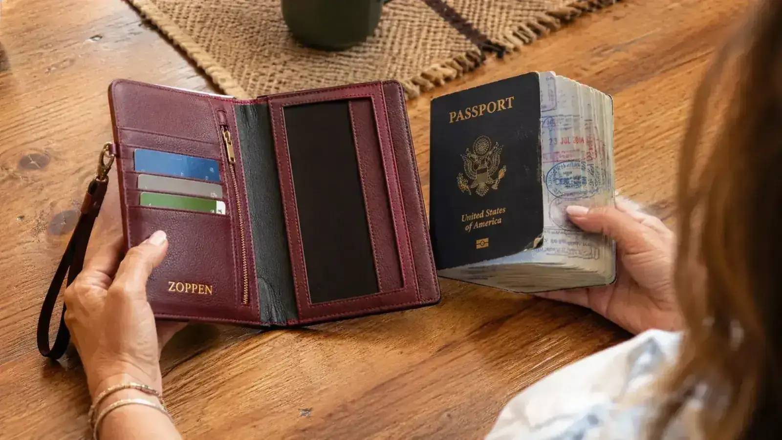 ZOPPEN passport wallet opened to reveal card slots, with a thick visa-stamped passport sitting beside it to show sizing comparison